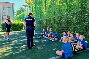 zdjęcie ze spotkania policjantki z dziećmi na boisku wśród bloków