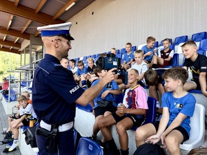 Policjant z miernikiem prędkości rozmawia z dźiećmi