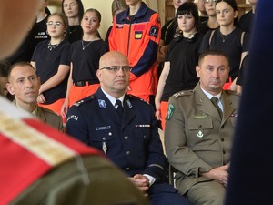 zdjęcie przedstawia komendantów służb mundurowych siedzących na krzesłach w sali gdzie odbywa się rozpoczęcie roku szkolnego