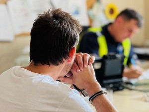 zdjęcie przedstawia policjanta z zatrzymanym kierowcą podczas przesłuchania