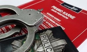 zdjęcie poglądowe przedstawiające książkę kodeks karny,  kajdanki i policyjną odznakę
