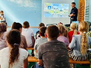 zdjęcie przedstawia wizytę policjanta w szkole na zajęciach z pierwszakami
