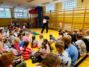 zdjęcie przedstawia wizytę policjanta w szkole na zajęciach z pierwszakami