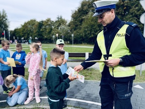 Policjant wręcza dyplom dziecku