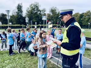 Policjant wręcza dyplom dziecku