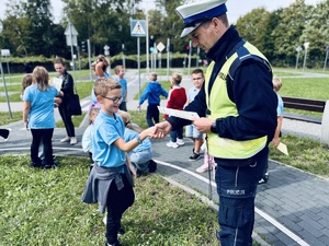 Policjant wręcza dyplom dziecku