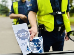 Na zdjęciu policjant wręczający ulotki