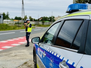 Na zdjęciu policjant w czasie pomiaru prędkości