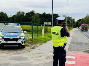Na zdjęciu policjant w czasie pomiaru prędkości