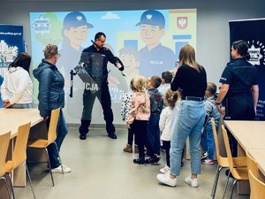 zdjęcie przedstawia przedszkolaków, którzy oglądają sprzęt policyjny