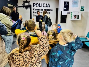 zdjęcie przedstawia przedszkolaków w holu wejściowym do rudzkiej komendy są witane przez policjantów