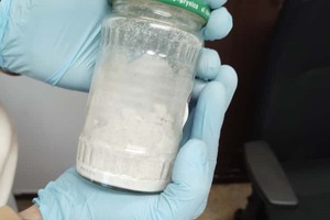 zdjęcie przedstawia zabezpieczony słoik z białym proszkiem