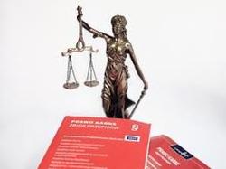 zdjęcie przedstawia figurkę temidy i dwa kodeksy leżące u jej stup