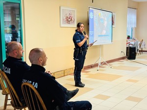 zdjęcie z debaty w domu pomocy społecznej przedstawia policjantkę w tracie swojego wystąpienia