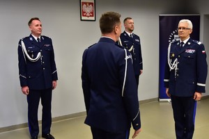 zdjęcie przedstawia salę w której odbywa się uroczysta zbiórka, na fotografii widać Komendanta Wojewódzkiego Policji i dowódcę uroczystości składającego meldunek