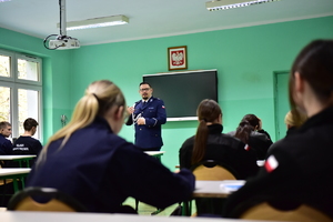 zdjęcie przedstawia klasę z uczniami oraz policjanta prowadzącego zajęcia