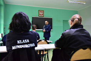 zdjęcie przedstawia klasę z uczniami oraz policjanta prowadzącego zajęcia