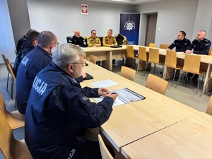 zdjęcie przedstawia salę odpraw z zebranymi policjantami i strażakami