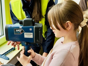 Zdjęcie przedstawia dziewczynkę oglądająca miernik prędkości