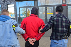 zdjęcie przedstawia policjantów kryminalnych prowadzących zatrzymanego sprawcę wypadku do rudzkiego sądu