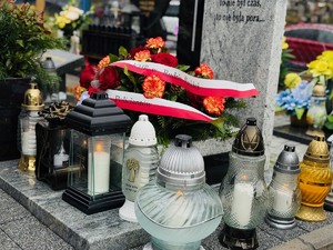 zdjęcie grób wraz z kwiatami i zniczami