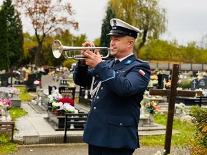 zdjęcie przedstawia policjanta z trąbką grającego sygnał śpij kolego