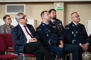 zdjęcie przedstawia siedzących na krzesłach policjantów i gości, między innymi rudzkiego komendanta