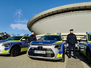 zdjęcie przedstawia nowy rudzki radiowóz wśród innych przekazywanych na tle katowickiego Spodka