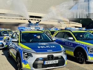 zdjęcie przedstawia nowy rudzki radiowóz a od tyłu widać wodę lejącą się na radiowozy z policyjnej armatki