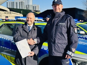 zdjęcie przedstawia komendanta i prezydenta przy radiowozie