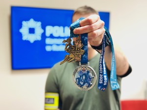zdjęcie rudzkiego policjanta trzymającego dwa ostatnio zdobyte medale