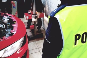 zdjęcie policjanta na stacji diagnostycznej w trakcie kontroli świateł