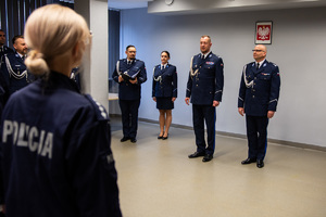 zdjęcie przedstawia miejsce uroczystej zbiórki w trakcie której komendant i jego zastępca stoją naprzeciw policjantów