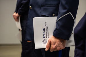 zdjęcie przedstawia miejsce uroczystej zbiórki w trakcie której akt mianowania w teczce trzymanej przez nowego oficera