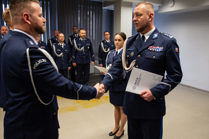 zdjęcie przedstawia miejsce uroczystej zbiórki w trakcie której komendant składa gratulacje nowemu oficerowi