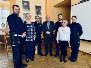 Policjanci pozują do zdjęcia z przedstawicielami grupy seniorów