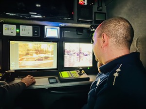 zdjęcie przedstawia policjanta ruchu drogowego w trakcie obserwacji skrzyżowania z mobilnego centrum monitorinngu