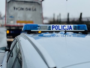 zdjęcie przedstawia radiowóz policyjny stojący za ciężarówką, której kierowca popełnił wykroczenie