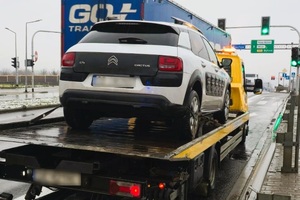 zdjęcie przedstawia auto lawetę na której platformie jest załadowany biały citroen