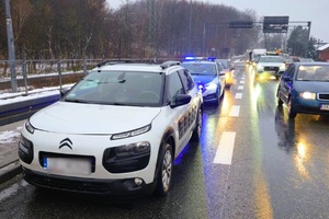 zdjęcie przedstawia ulicę na której stoi biały citroen a za nim policyjny radiowóz