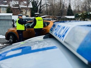 zdjęcie przedstawia policjantów z drogówki w trakcie rozmowy z kierowcą, który przekroczył prędkość
