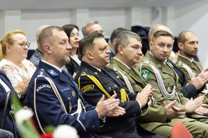 zdjęcie przedstawia siedzących na krzesłach zaproszonych gości, między innymi szefa rudzkich policjantów