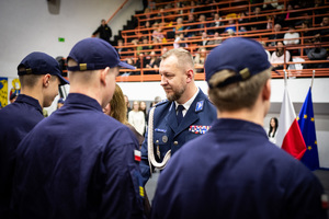 zdjęcie przedstawia komendanta wręczającego uczniom akty mianowania