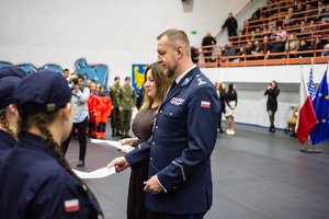 zdjęcie przedstawia wręczanie aktów mianowania uczniom klasy mundurowej przez komendanta policji