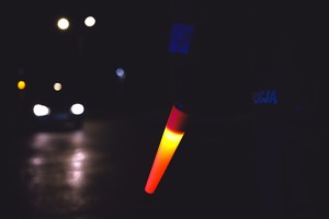 zdjęcie policyjnej latarki do zatrzymywania pojazdów, trzymanej przez policjantkę na drodze