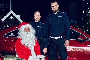 zdjęcie przedstawia policjantkę i policjanta przy siedzącym świętym Mikołaju