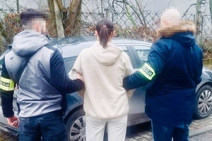 zdjęcie policjantów z zatrzymaną kobietą przed samochodem