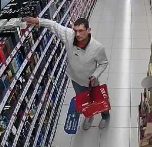 zdjęcie sprawcy kradnącego towar ze sklepowej półki