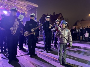 zdjęcie z koncertu policyjnej orkiestry na rudzkim jarmarku - policyjni muzycy i dziewczynka z buławą