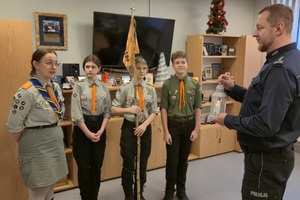 zdjęcie przedstawia harcerzy przekazujących komendantowi Betlejemskie Światełko Pokoju w gabinecie szefa rudzkiej Policji